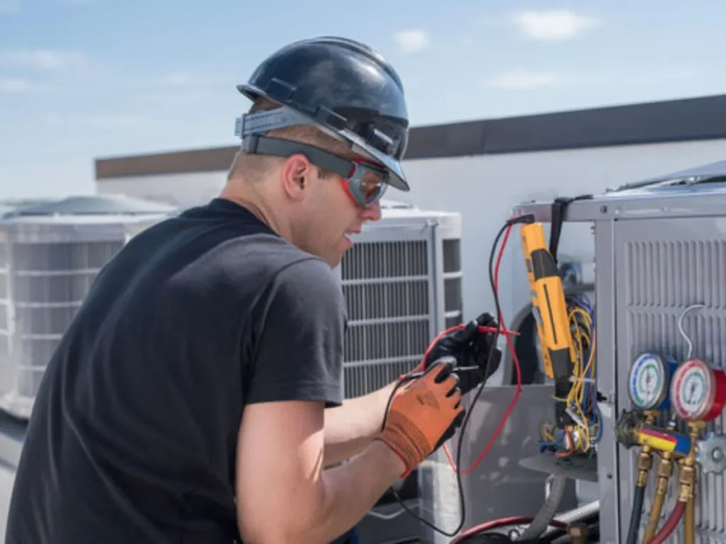 HVAC technician in San Antonio performing commercial AC repair on a rooftop unit using diagnostic tools.